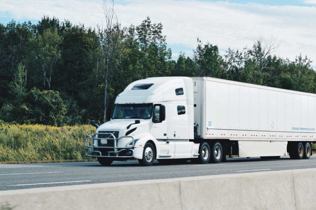 All white truck driving on the highway | Featured image for the Tips for Buying Your First Semi Truck Blog for Truck Finance Australia